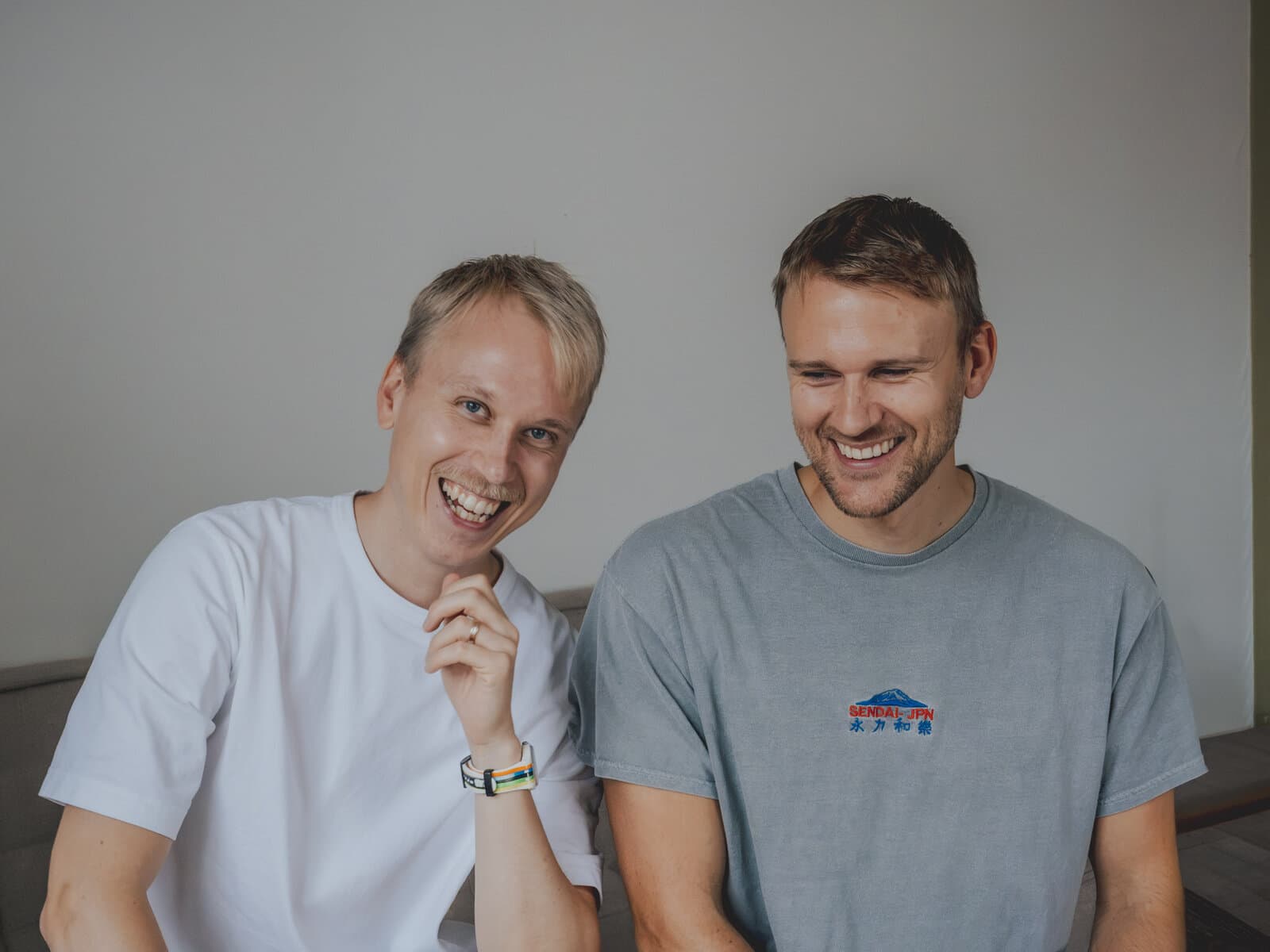 Max och Adam, som driver Skriveriet, skrattar tillsammans i en soffa